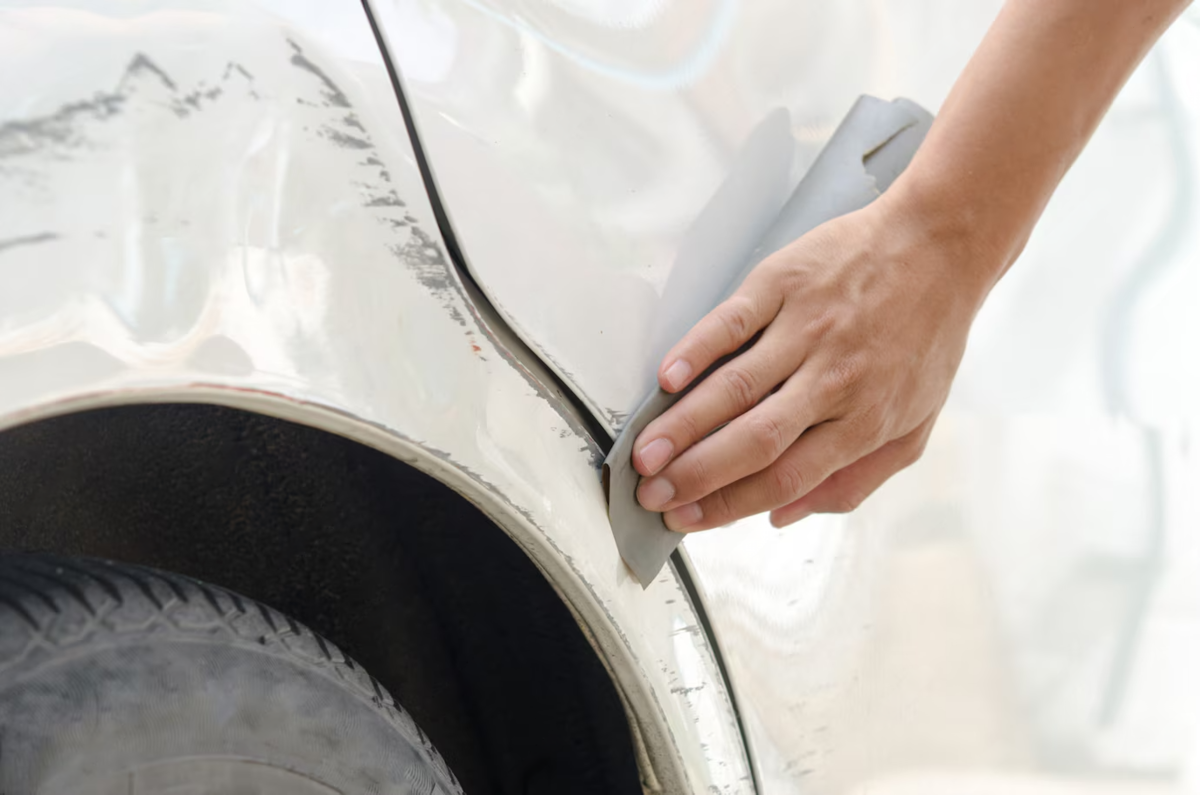 Eliminació professional d'una ratllada al lateral d'un vehicle blanc per restaurar l’aspecte original sense deixar rastres del dany.